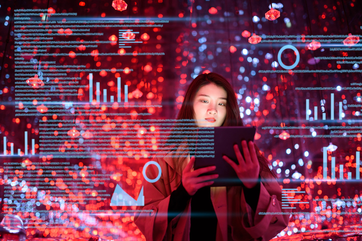 A young woman looking at a tablet computer with an overlay of digital data visualizations